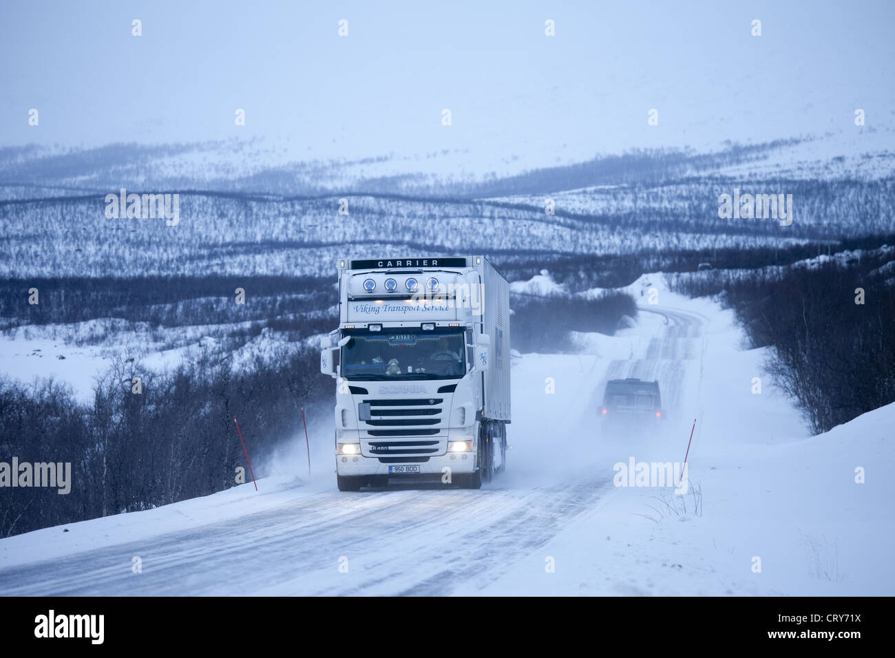 Viking-Transport-Service Truck fährt durch die arktische Wildnis bei Einbruch der Dunkelheit von Kilpisjarvi auf dem Weg von Norwegen nach Finnland Stockfoto