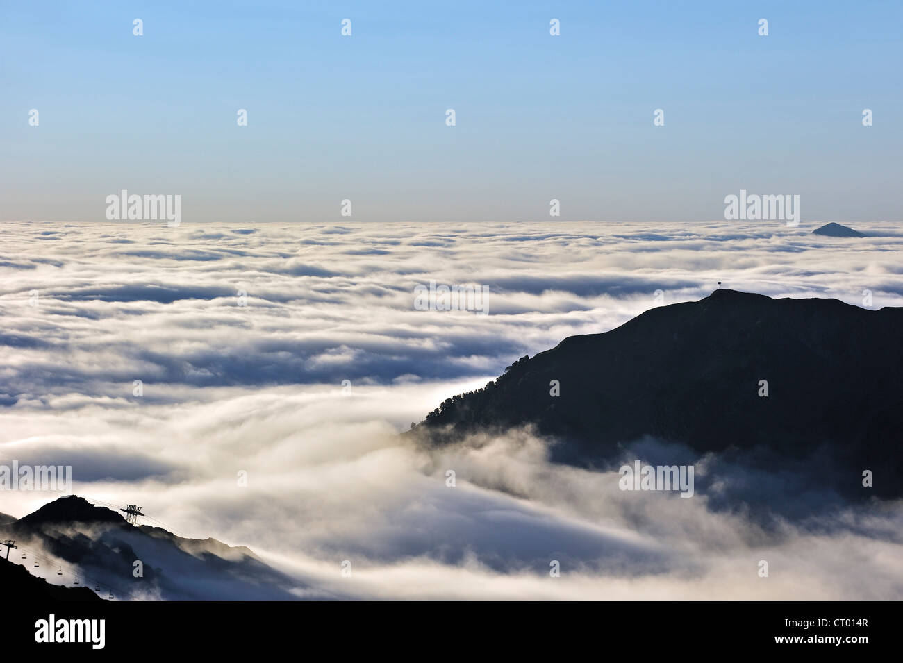 Blick über die Silhouette Sesselbahnen und Berge im Nebel bei Sonnenaufgang, Col du Tourmalet, Hautes-Pyrénées, Pyrenäen, Frankreich Stockfoto