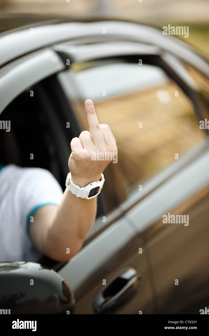 junger Fahrer zeigt Mittelfinger, natürliches Licht, selektiven