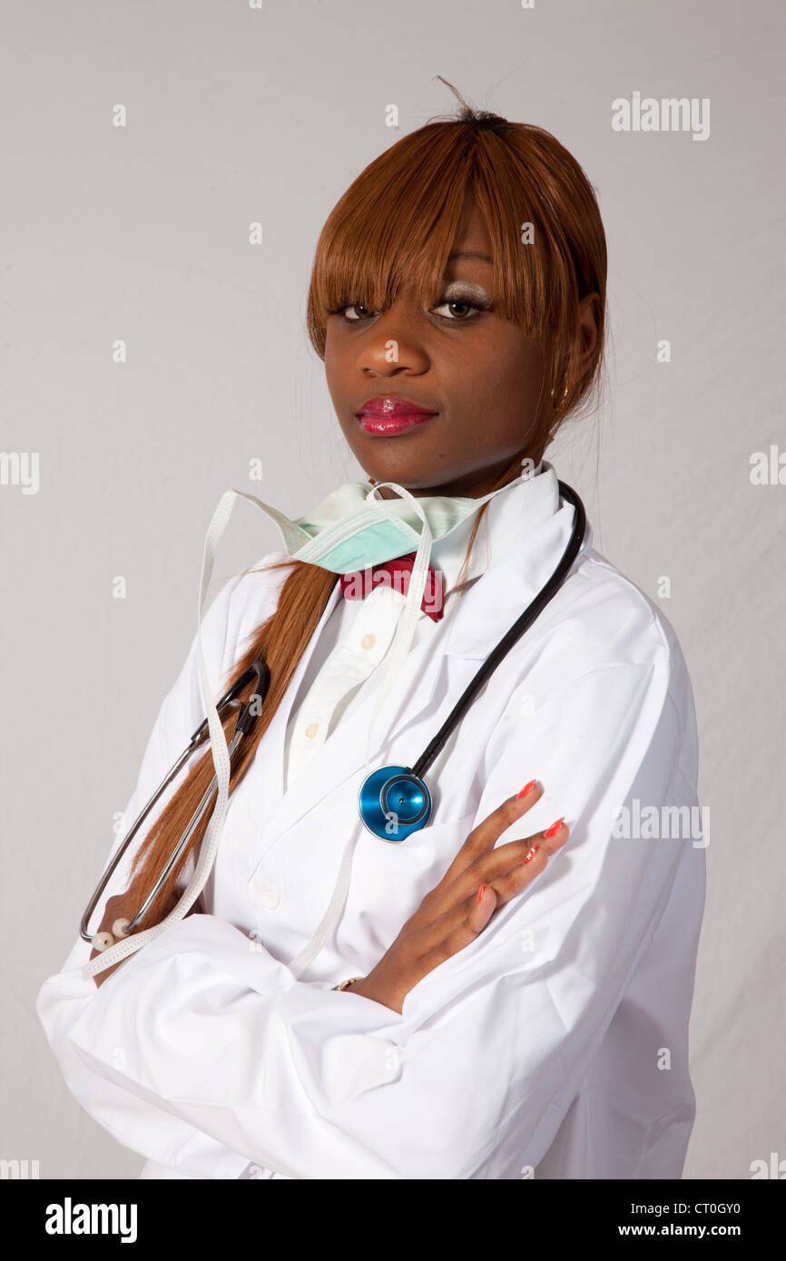 Hübsche junge schwarze Gesundheitswesen Arbeitnehmerin im Laborkittel mit einem Stethoskop, schaut in die Kamera mit einer nachdenklichen schauen Stockfoto