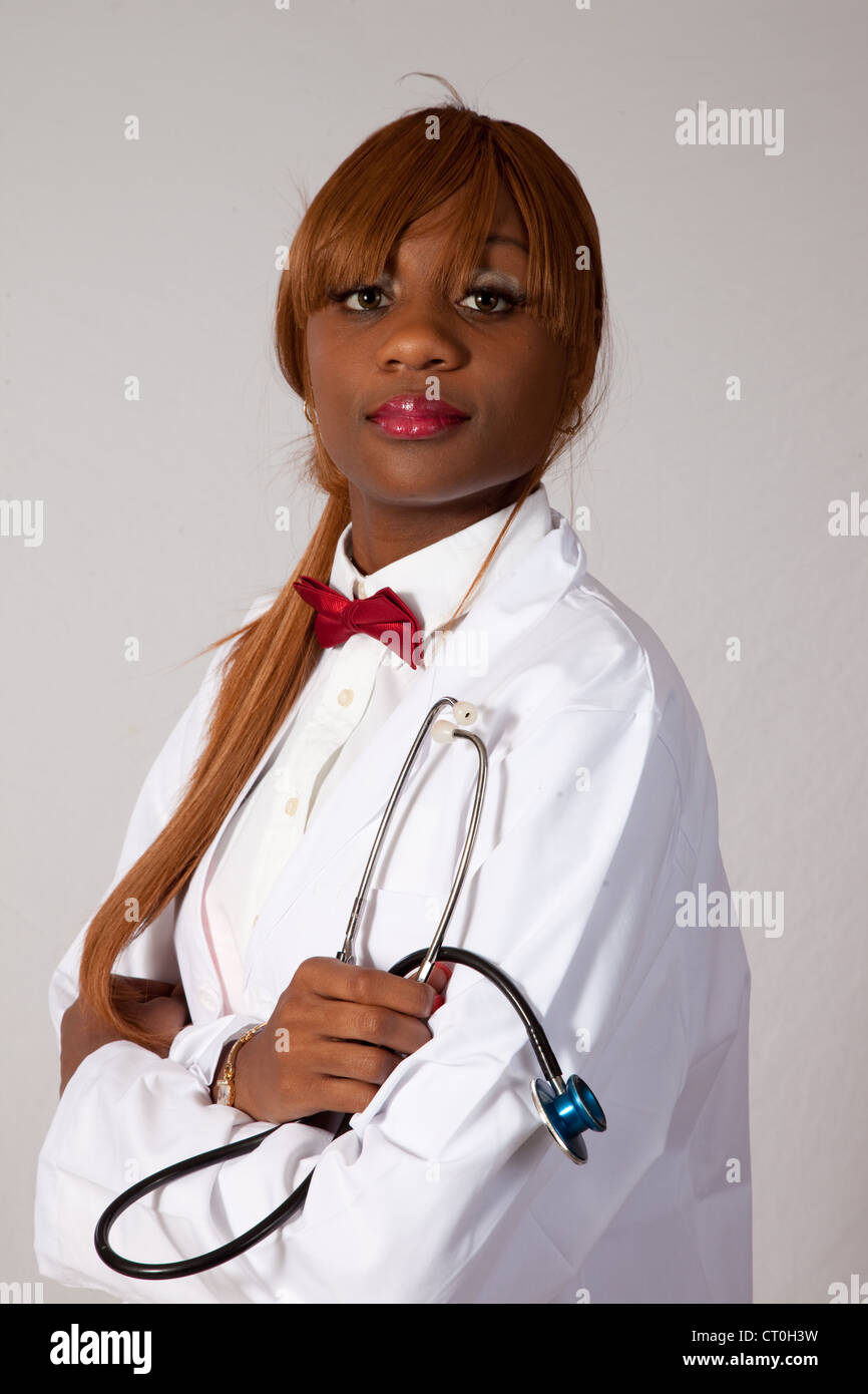 Hübsche junge schwarze Gesundheitswesen Arbeitnehmerin im Laborkittel mit einem Stethoskop, schaut in die Kamera mit einer nachdenklichen schauen Stockfoto