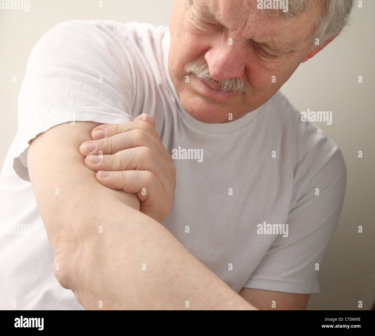 ein älterer Mann leidet unter Schmerzen in seinem Oberarm Stockfoto