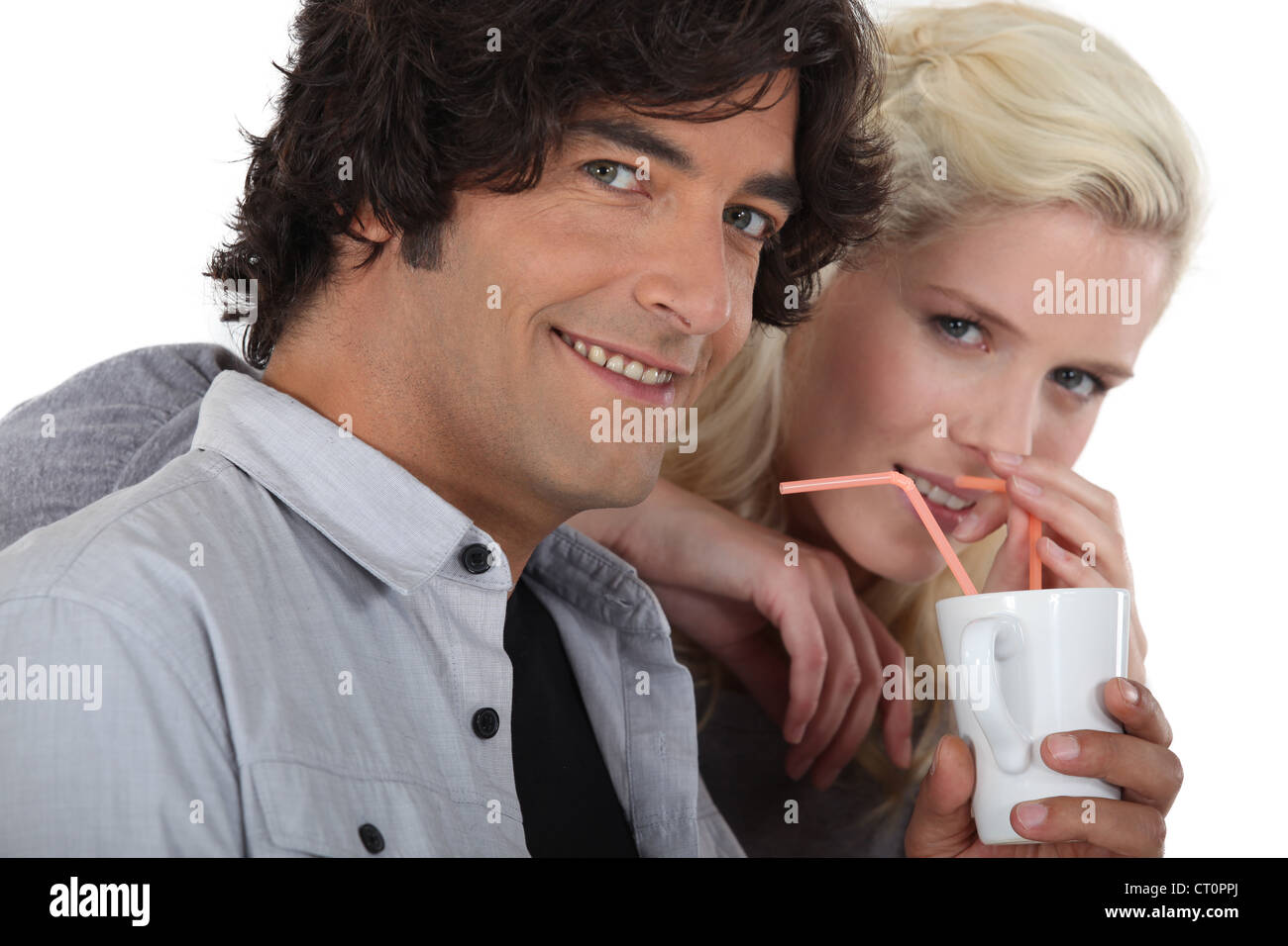Paar aus dem gleichen Becher mit Strohhalmen trinken Stockfoto