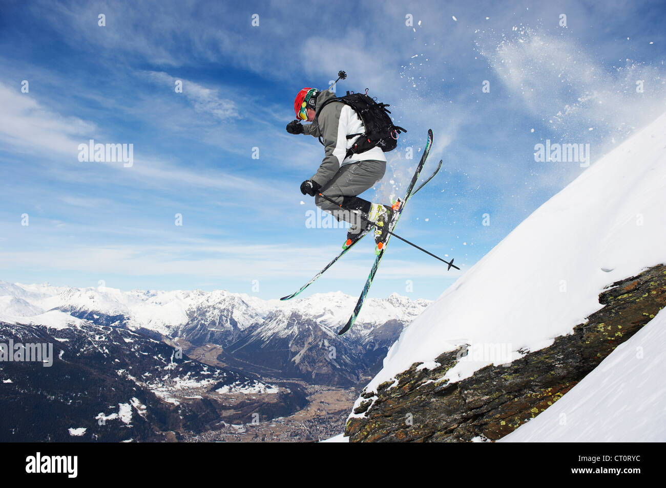 Skifahrer vom verschneiten Hang springen Stockfoto