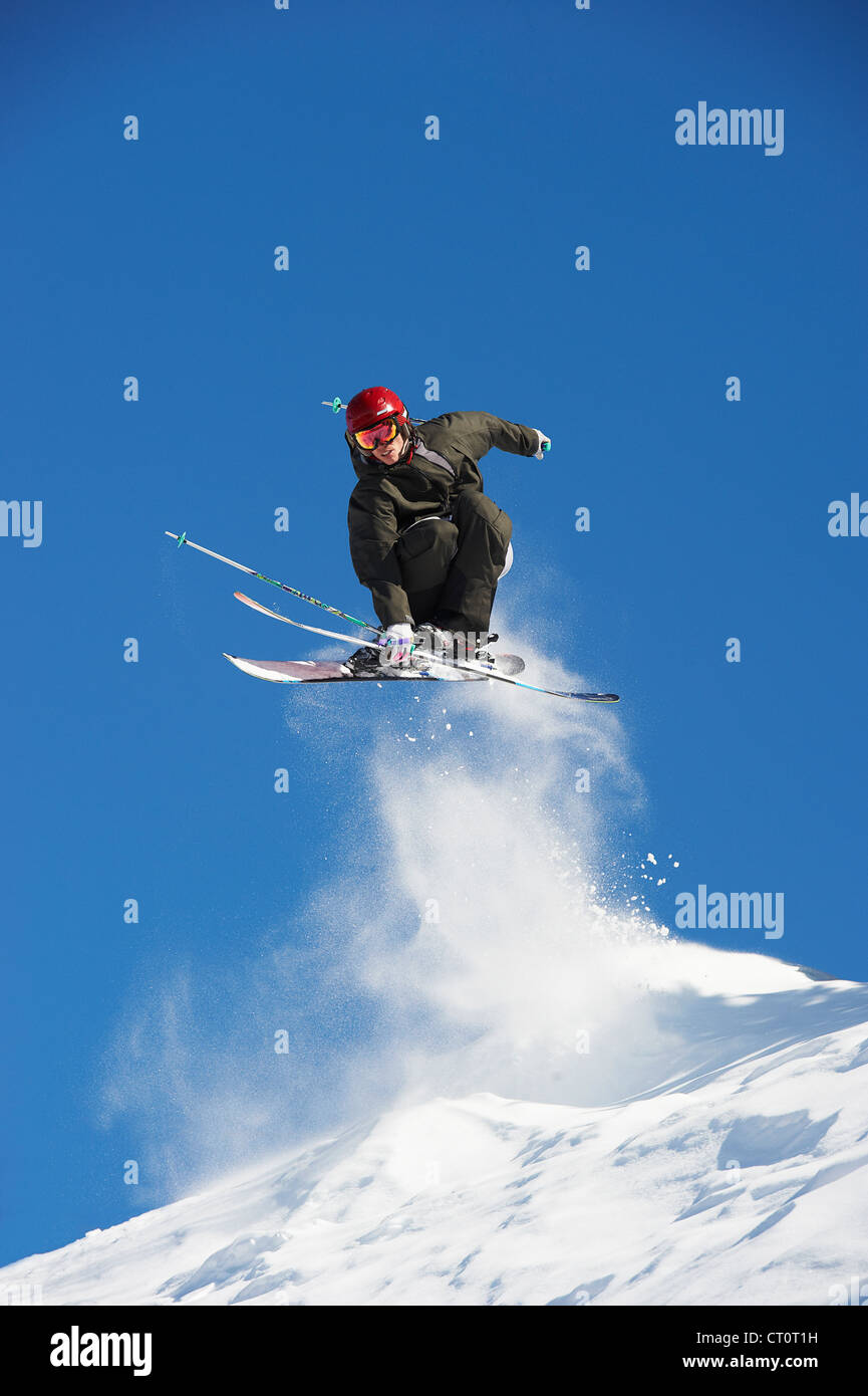 Skifahrer vom verschneiten Hang springen Stockfoto