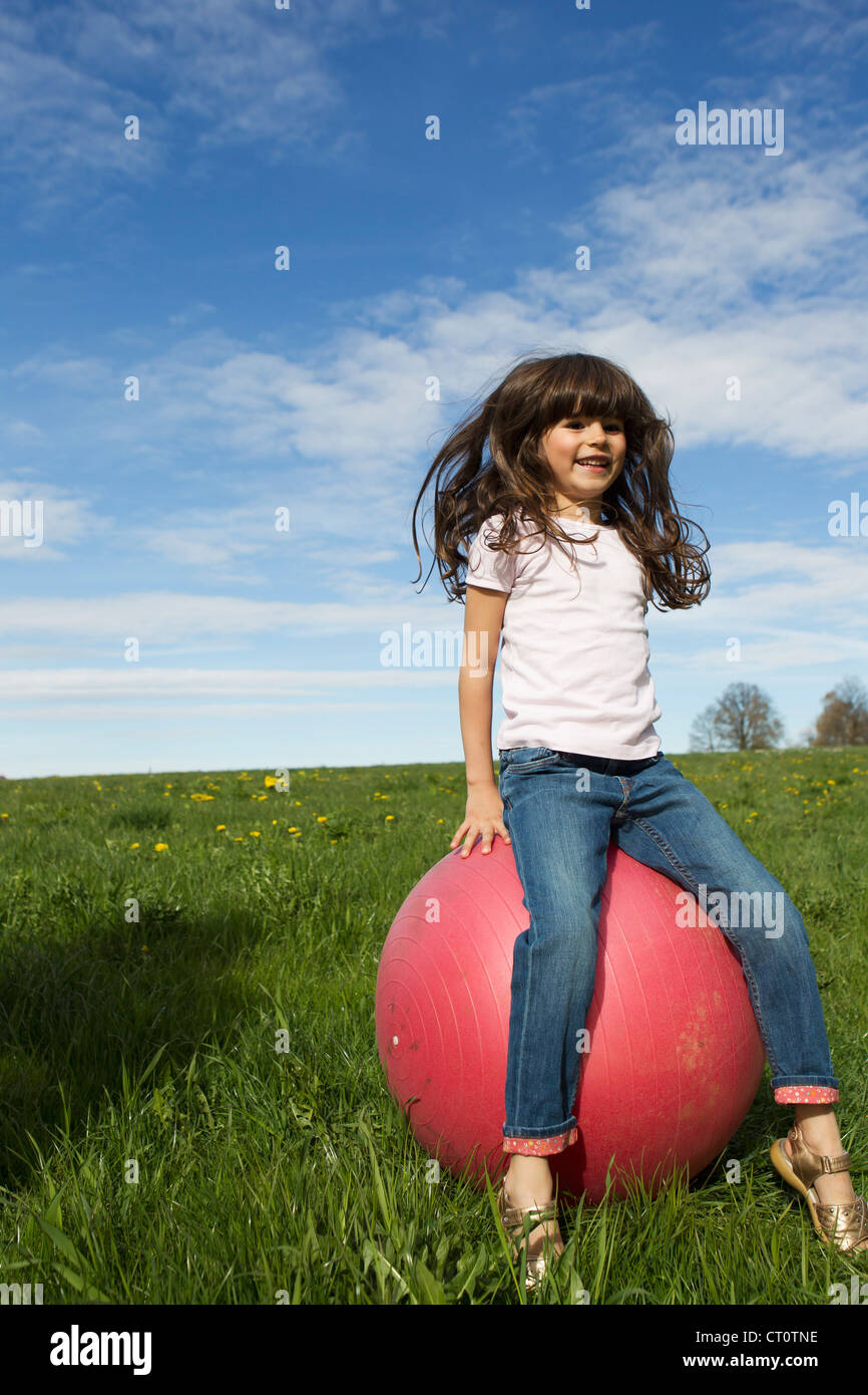 Mädchen spielen auf bouncy Ball im freien Stockfoto