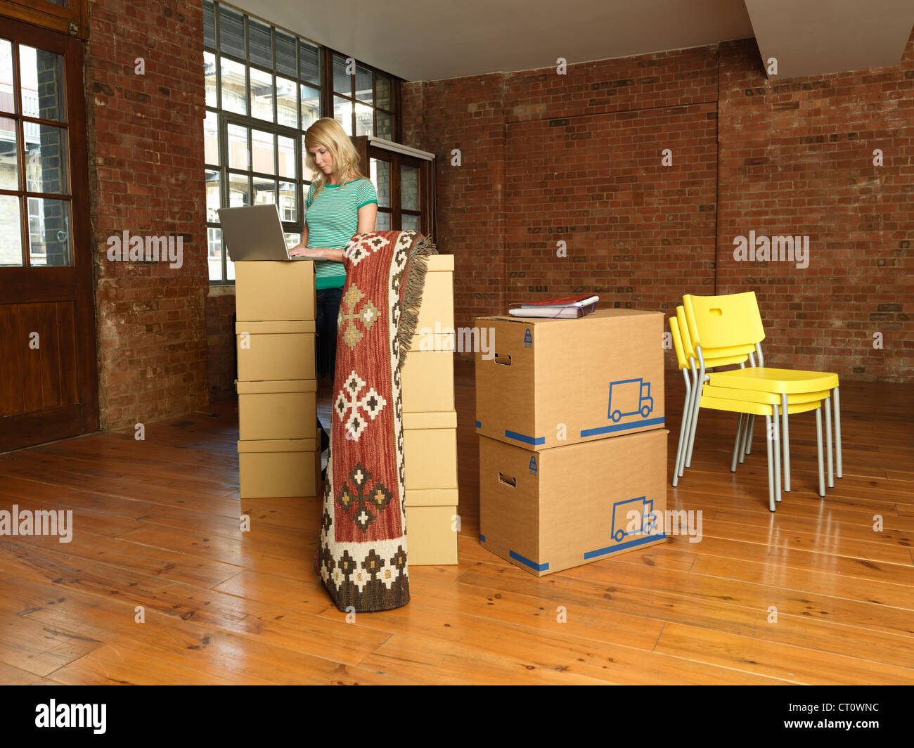 Frau mit Karton Boxen im neuen Zuhause Stockfoto
