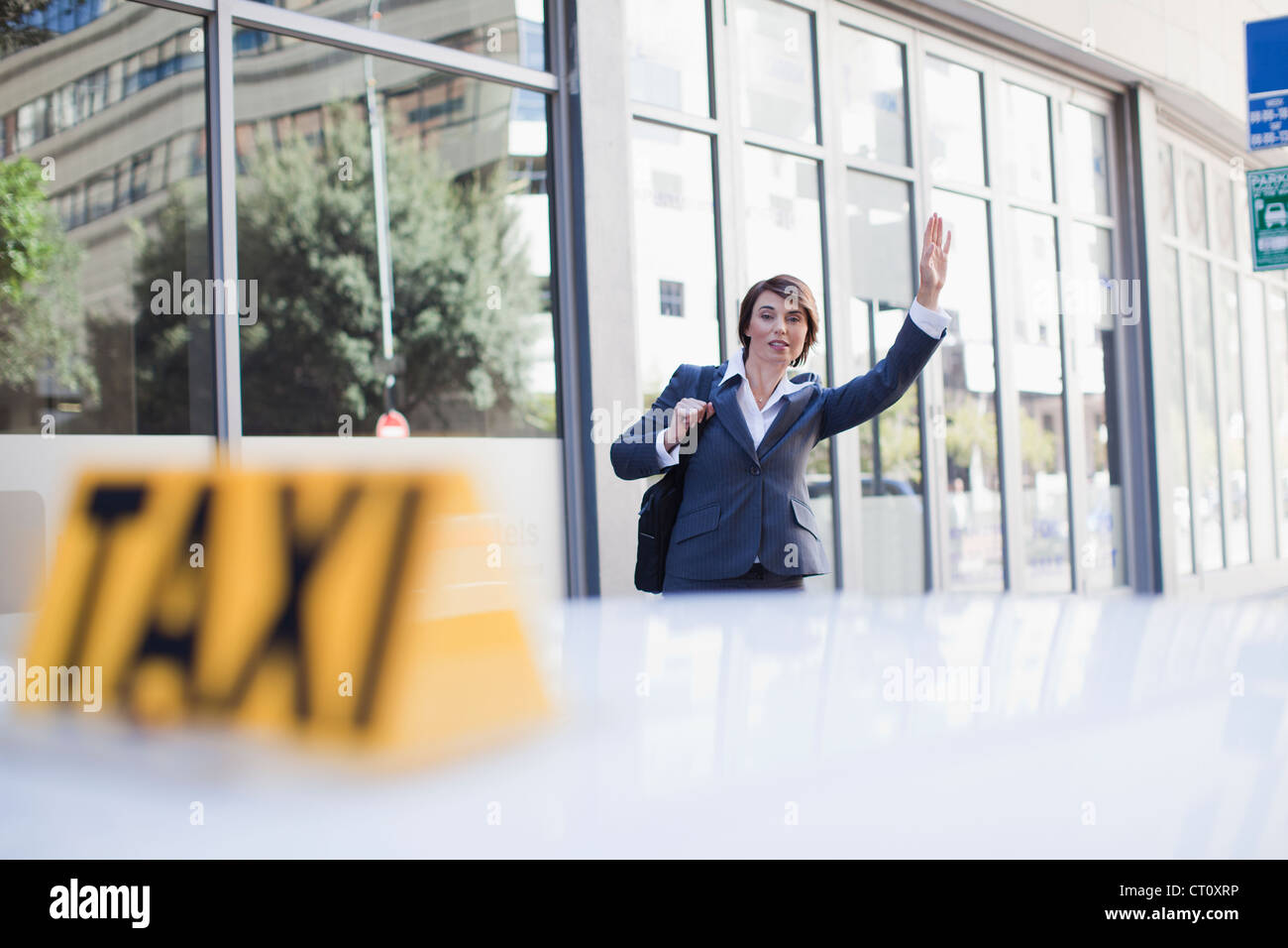 Geschäftsfrau hagelt Taxi auf Straße Stockfoto