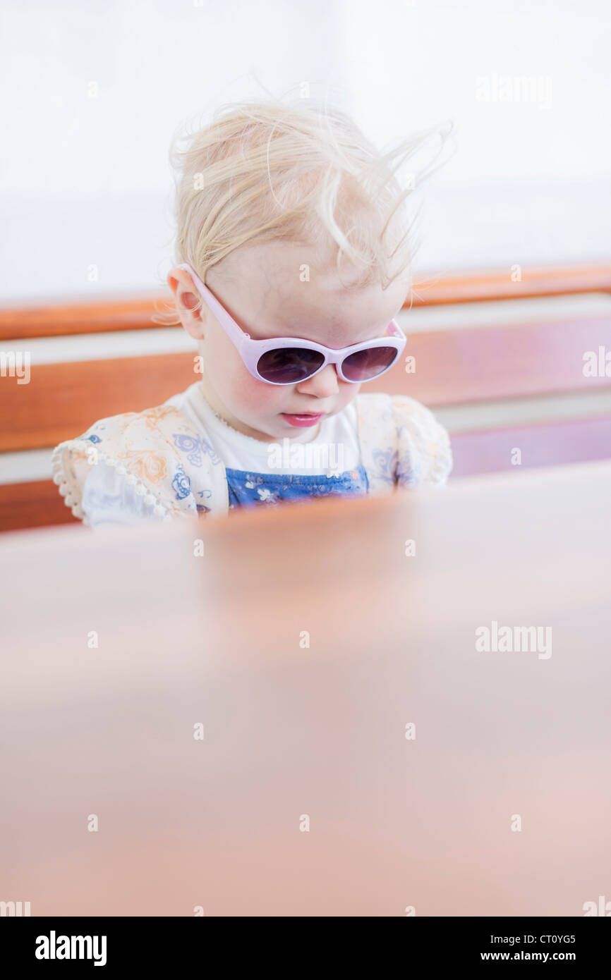 Kleinkind Mädchen mit Sonnenbrille im Innenbereich Stockfoto
