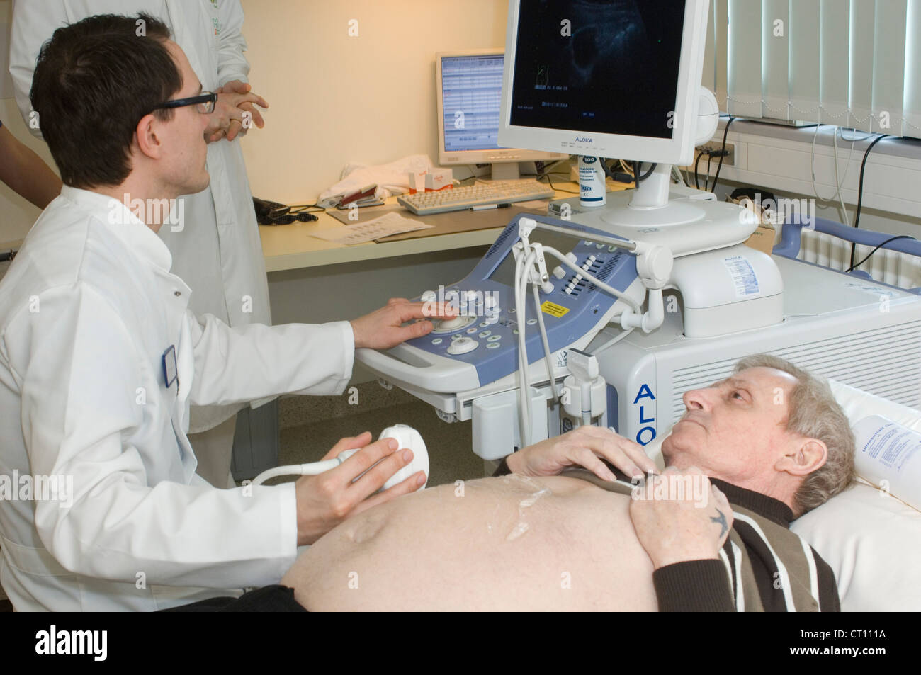 Ein Mann ein Verfahren um einen vermuteten Hernie zu erkennen. Stockfoto