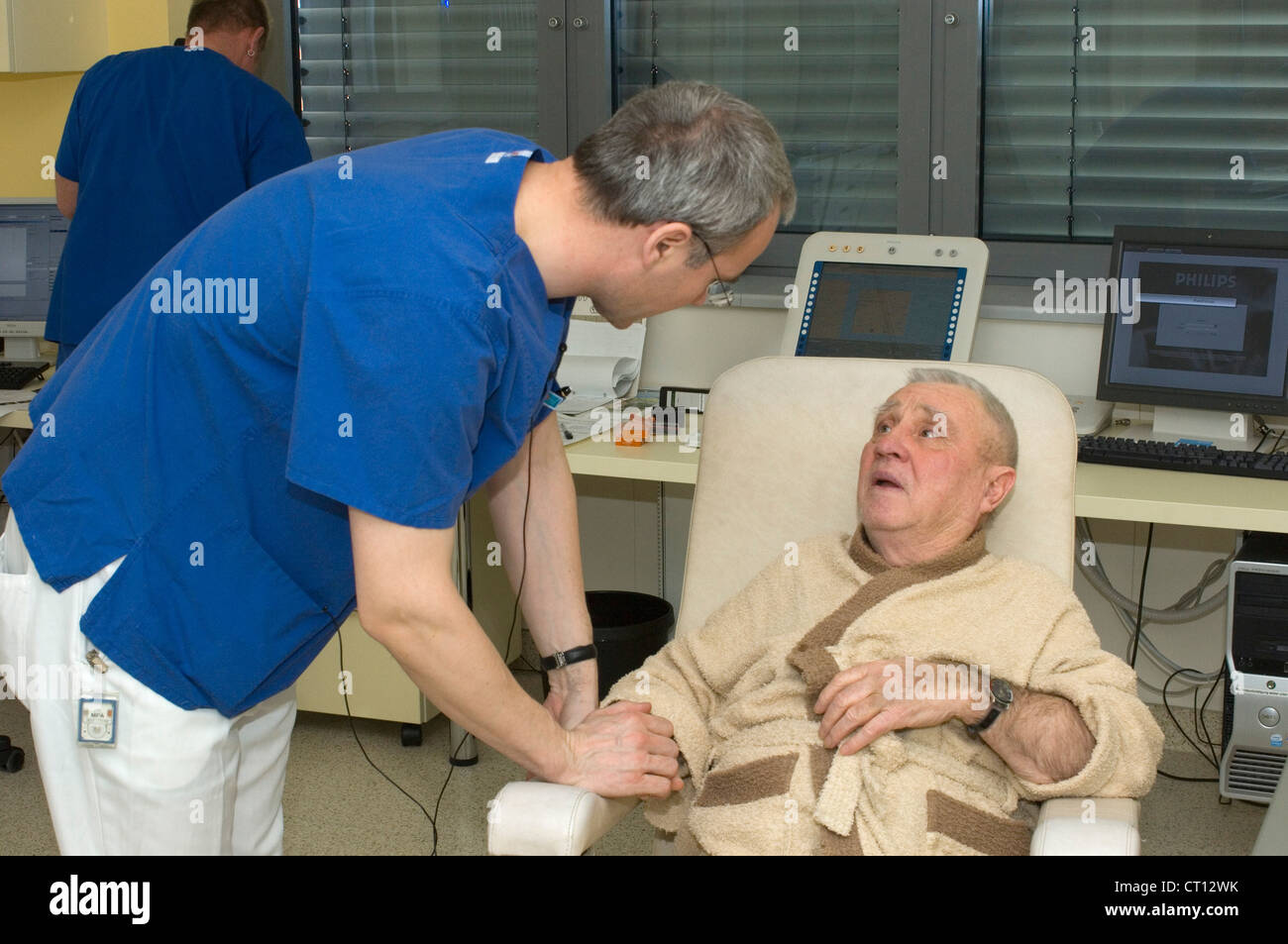 Ein älterer Mann sitzen und im Gespräch mit einem Arzt nach einer endoskopischen Verfahren. Stockfoto