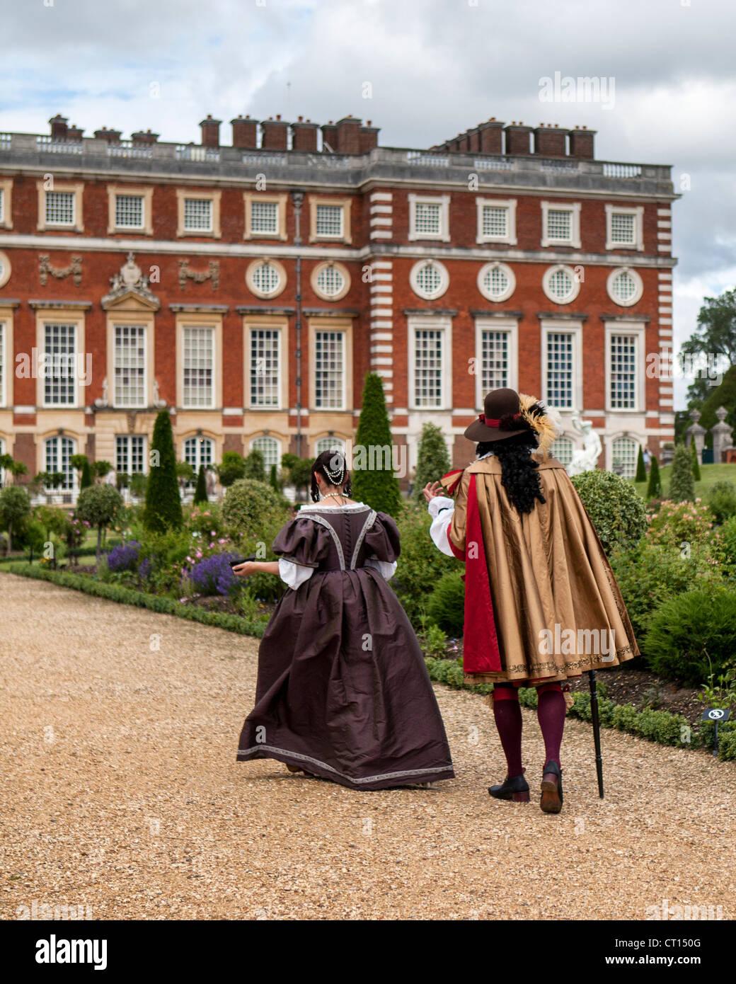 Mann und Frau im Zeitraum Kleid im geheimen Garten vor Christopher Wren Erweiterung des Hampton Court Palace Stockfoto