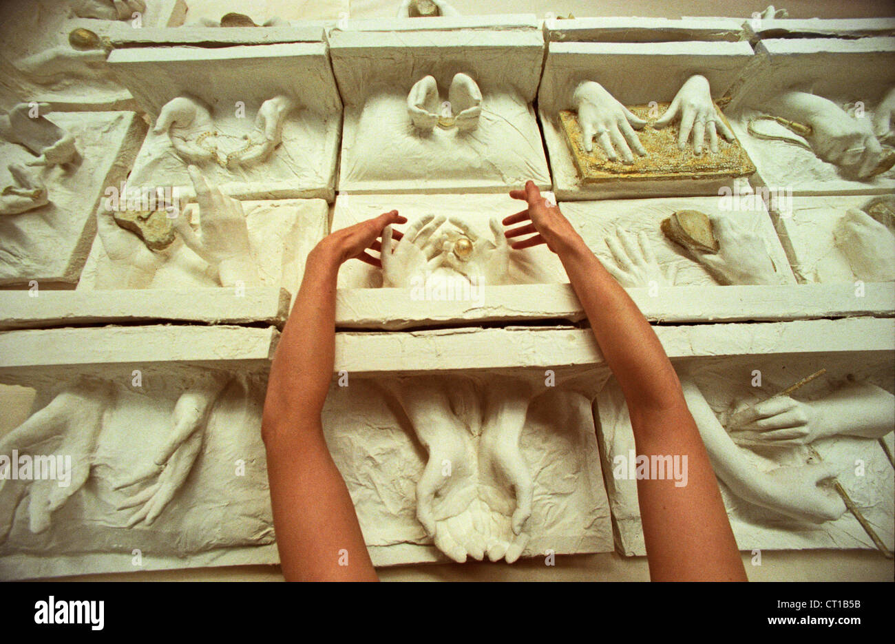 Eine Künstlerin, die Vermittlung von Gipsabgüssen Womens Hände als Symbol für Arbeit von Frauen in der Welt ist sein Gewicht in Gold Wert Stockfoto
