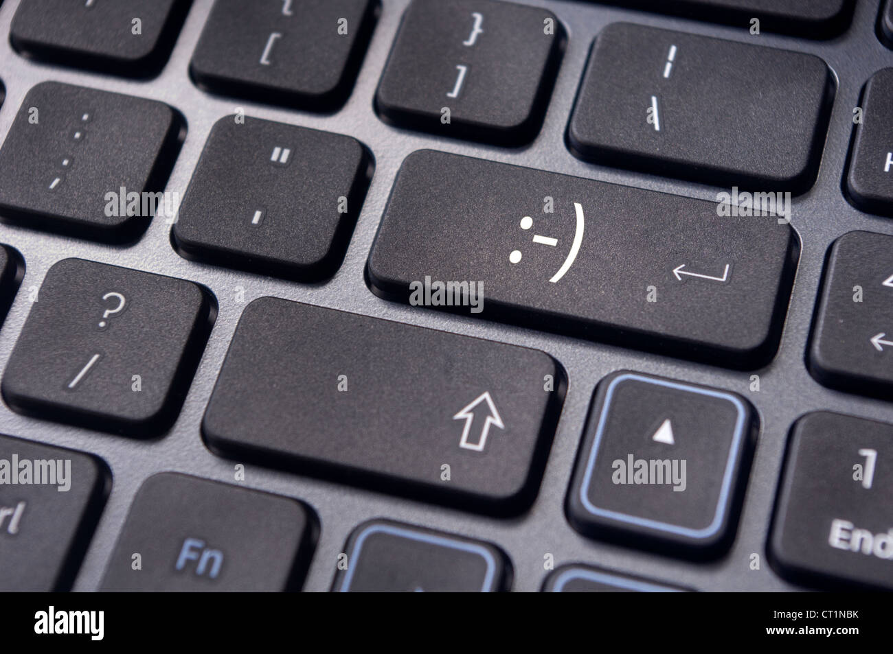 ein glückliches Smiley-Zeichen auf enter-Taste der Tastatur. Stockfoto