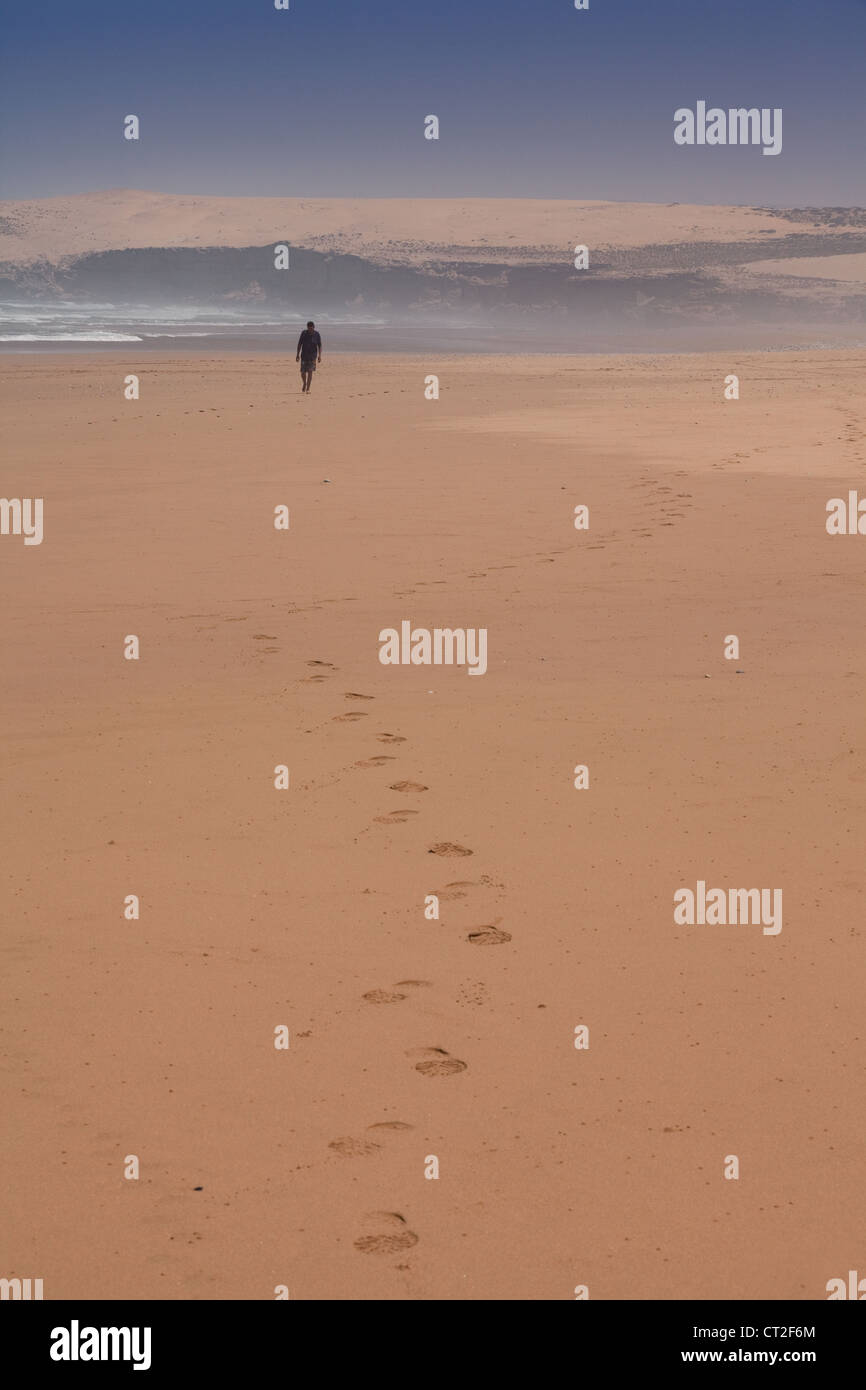 eine Person, die zu Fuß auf einem einsamen Strand in der Nähe von Agadir, Marokko Afrika Stockfoto
