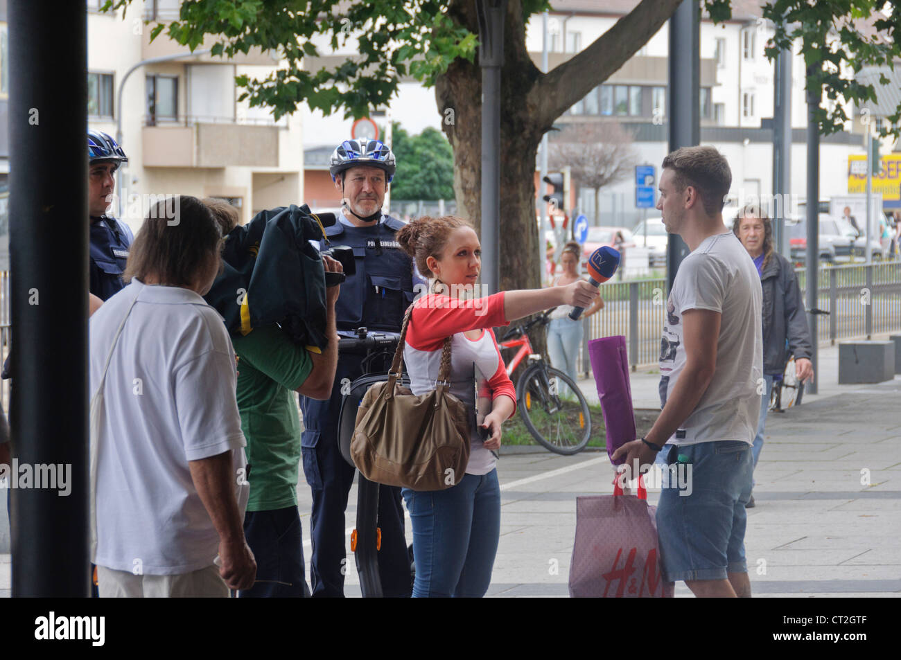 Fernsehteam männlichen Kameramann Reporterin Interview auf Straße mit Menschen in der Öffentlichkeit - Heilbronn, Deutschland Stockfoto