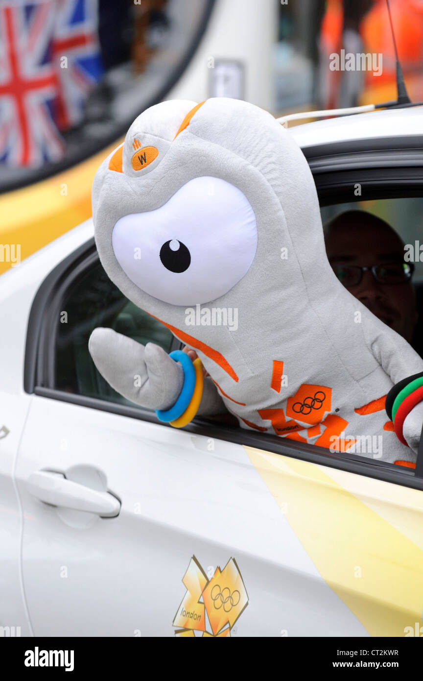 "Wenlock" Wellen der London 2012 Olympische Maskottchen aus dem Autofenster eines Fahrzeugs der Olympischen Fackel Prozession. Stockfoto