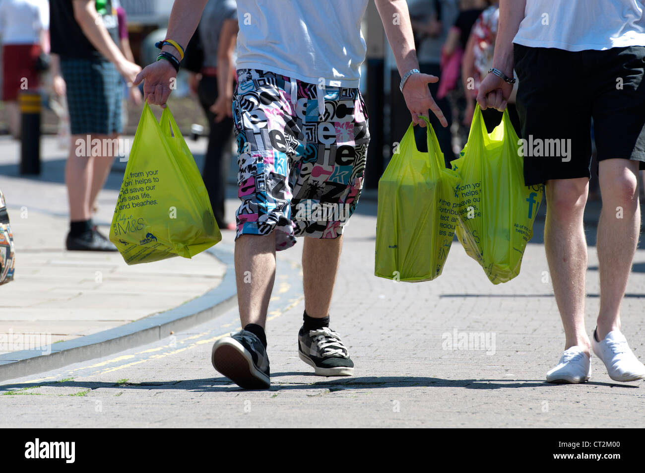 Männer tragen Kunststoff-Tragetaschen Shopping Stockfoto