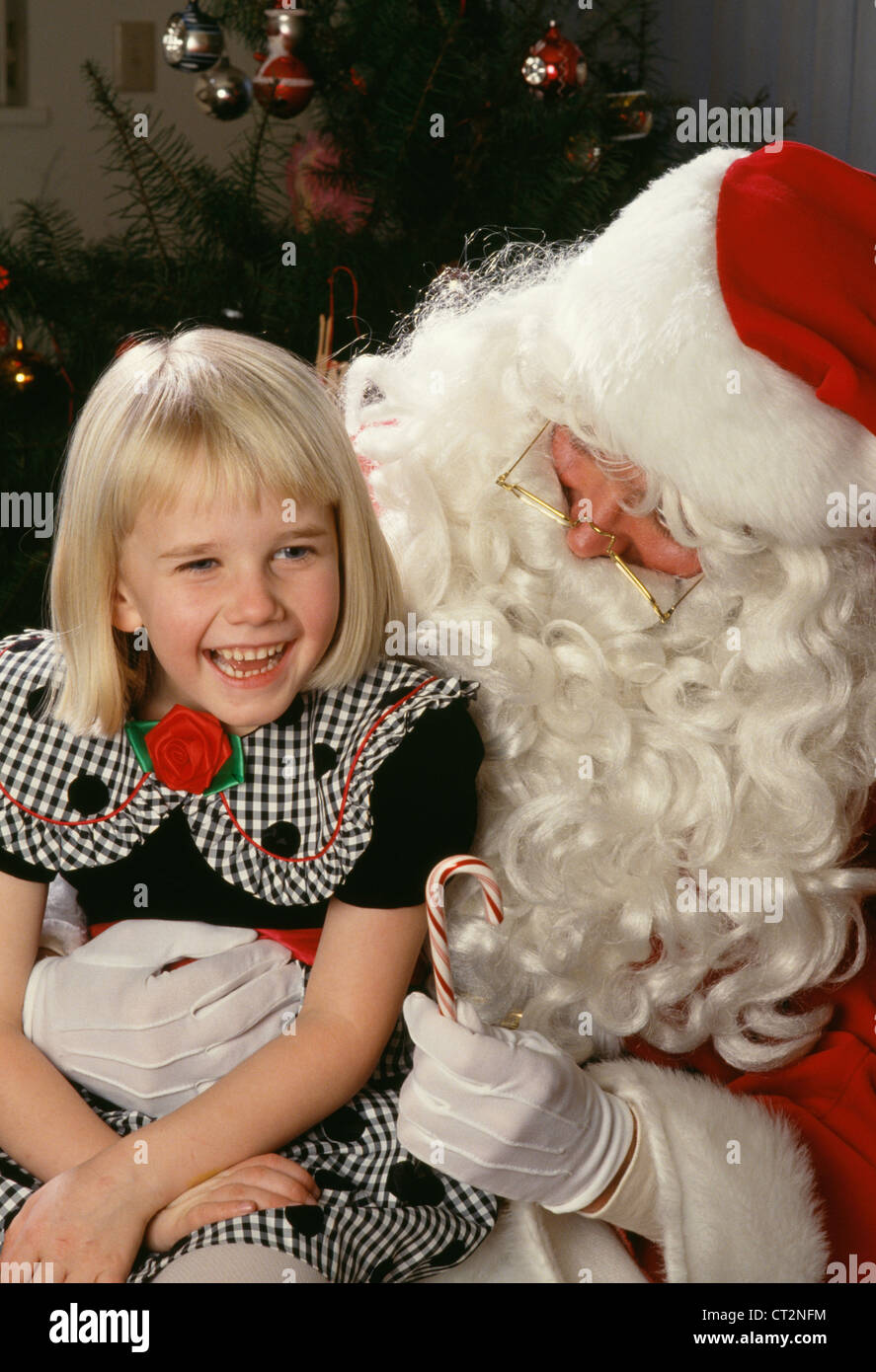 Sechs Jahre altes Kind und Weihnachtsmann lachen mit Zuckerrohr, USA 1990er Jahre Stockfoto