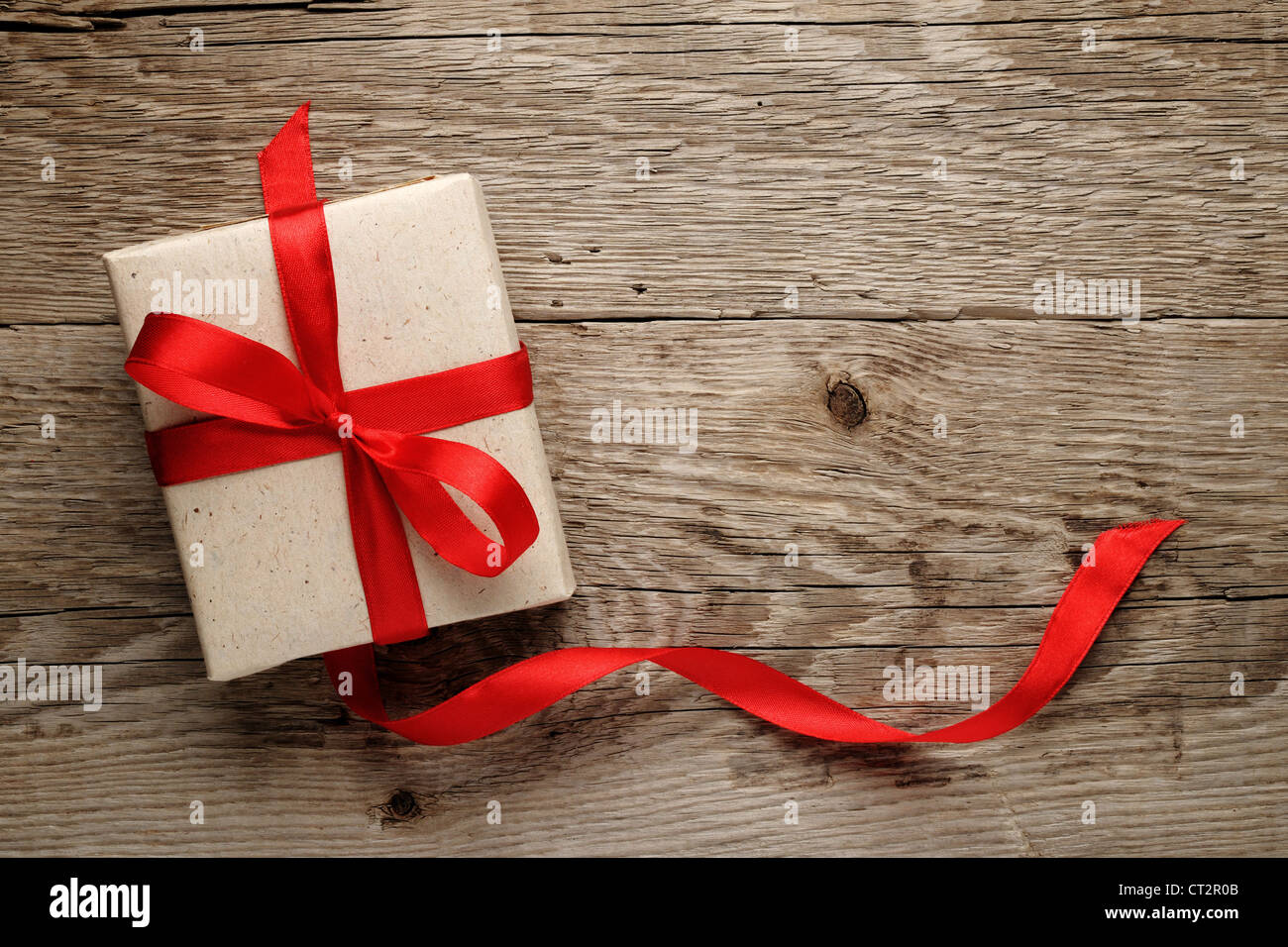 Geschenk-Box mit roter Schleife auf Holz Hintergrund Stockfoto