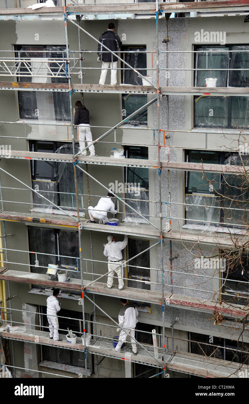 Arbeiter auf einem Gerüst, Isolierung eines Mehrfamilienhauses. Stockfoto