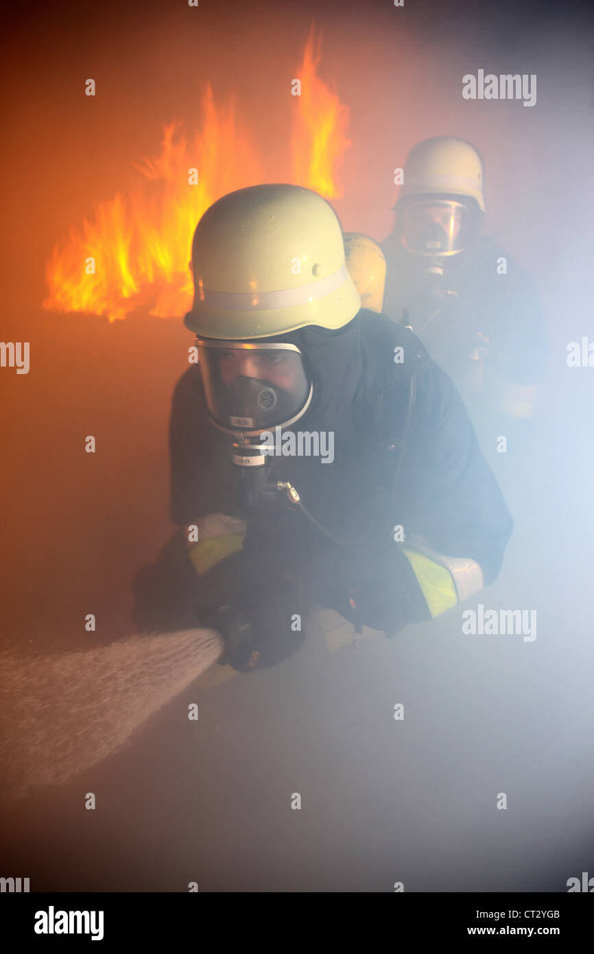Feuerwehr, Feuer Männer, Brandbekämpfung Training bei einem Feuer Ausbildung. Feuerwehrleute mit Atemschutz. Stockfoto