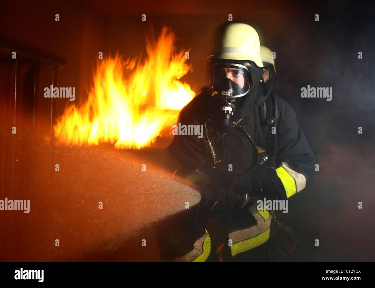 Feuerwehr, Feuer Männer, Brandbekämpfung Training bei einem Feuer Ausbildung. Feuerwehrleute mit Atemschutz. Stockfoto