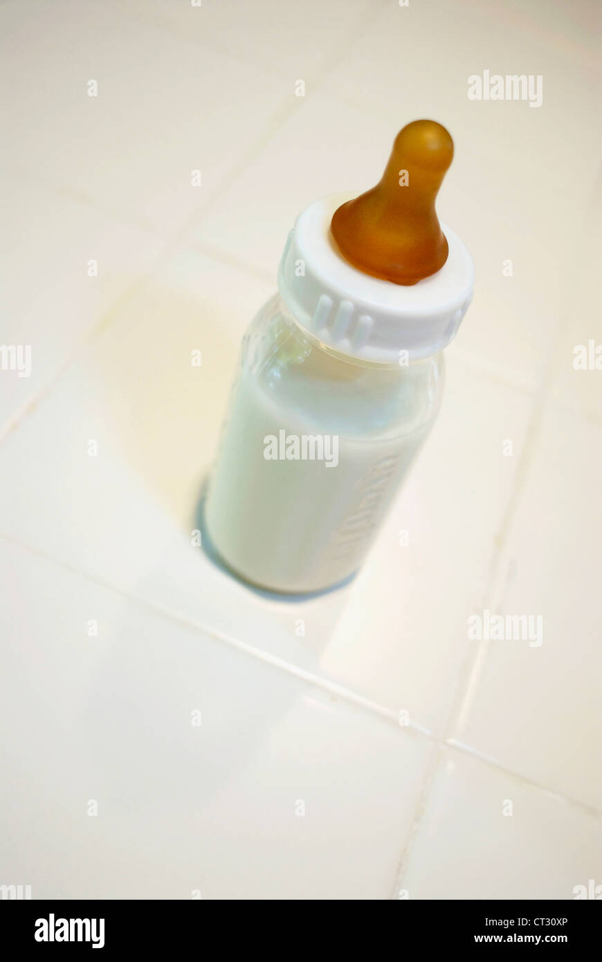 Eine Babyflasche gefüllt mit Milch sitzt an einer Theke. Stockfoto
