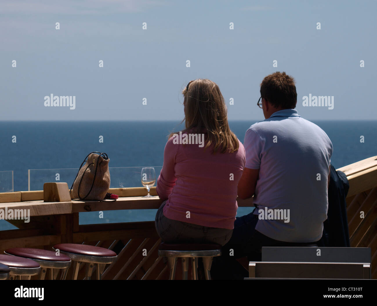 Paar genießt einen Drink in einer Bar mit Blick aufs Meer, Lyme Regis, Dorset, Großbritannien Stockfoto