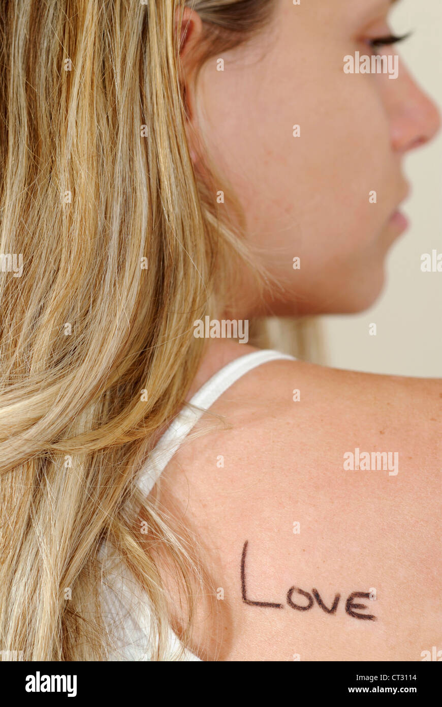 Eine Frau mit Liebe geschrieben auf die Schulter. Stockfoto