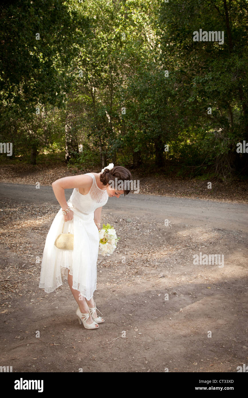 Braut mit Blumen blickte auf ihre Schuhe. Stockfoto