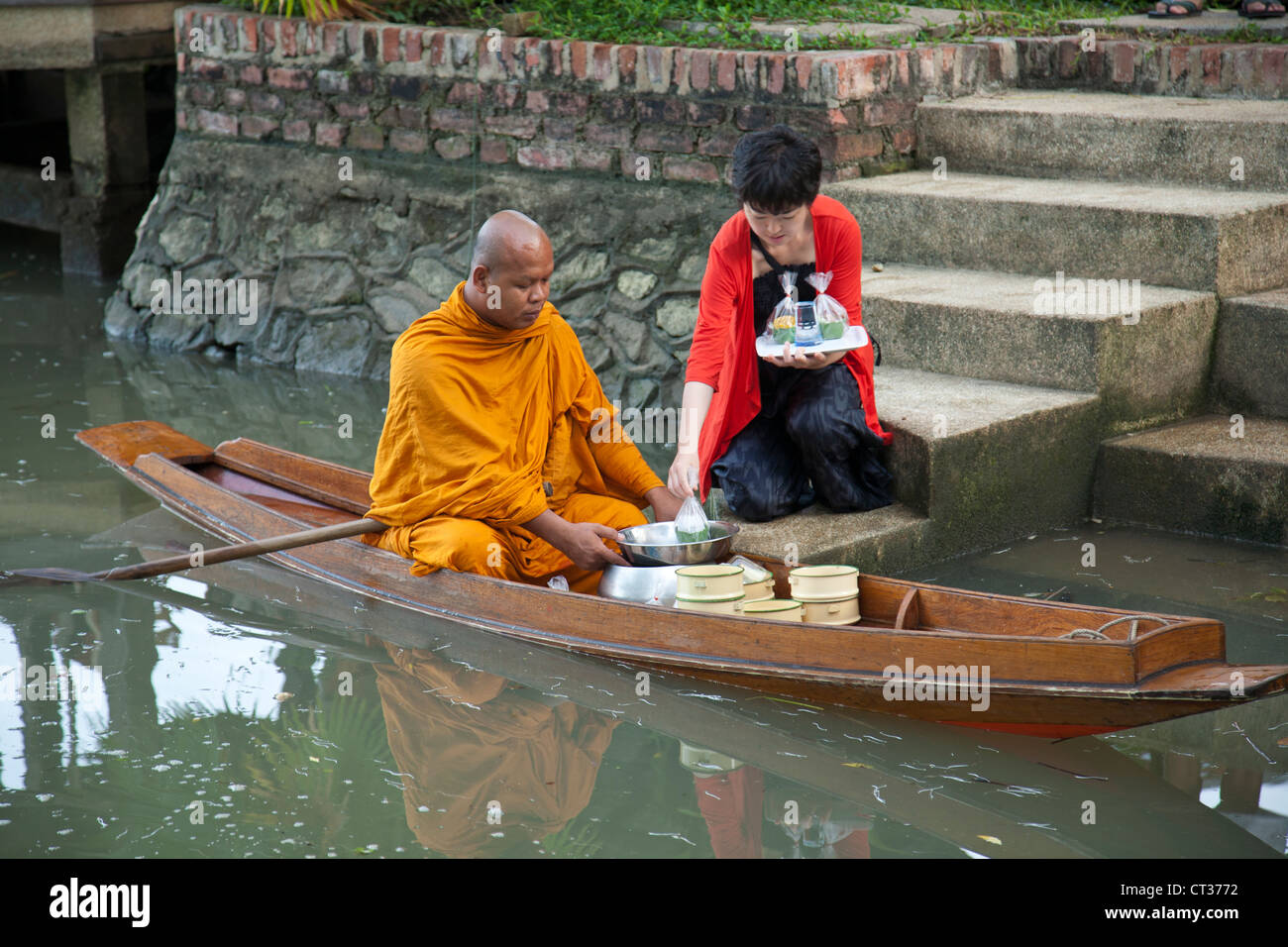 Thai Mönch Reisen von Tempel zu Tempel und sammeln Sie Almosen auf ihre Runden am Morgen mit dem Boot in Amphawa. Stockfoto