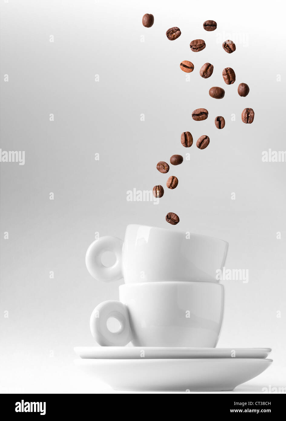 Doppelter Espresso Metapher mit Kaffeebohnen Stream als ein Rauch über zwei Kapitälchen Stockfoto