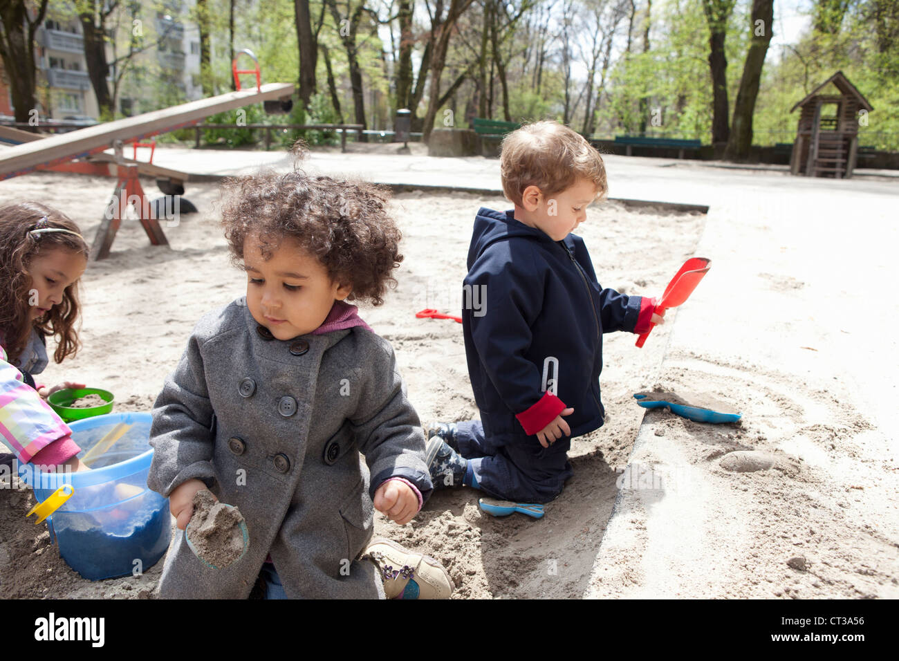 Kinder spielen mit Sand auf Spielplatz Stockfoto