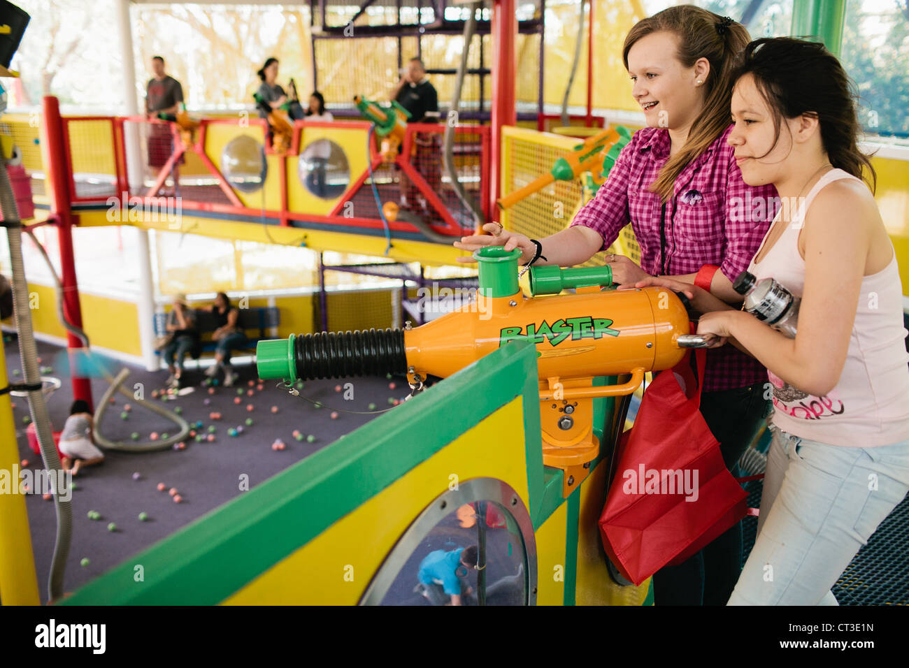 Zwei Mädchen mit einem weichen Ball schießen Kanonen in neugierig George geht zur Stadt Ballsaal Universal Studios in Orlando, Florida, USA Stockfoto