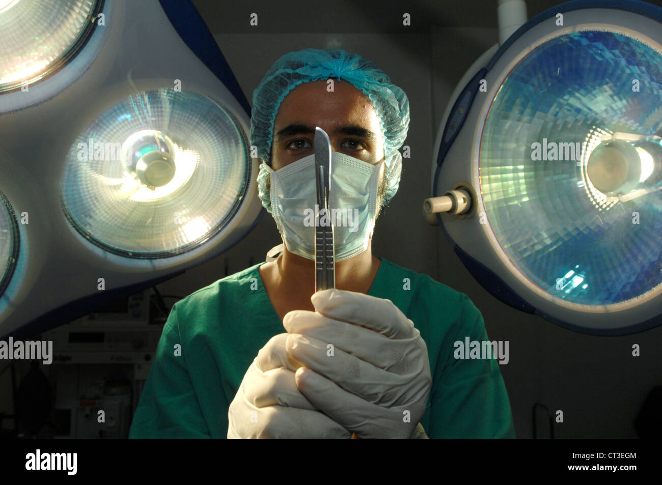 Ein Krankenhaus Chirurg mit einem Skalpell unter einem OP-Saal-Licht. Stockfoto