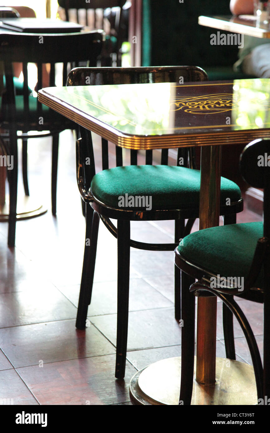Es ist ein Foto von einem typischen Paris Stil Tisch in einer Restaurantbar. Es gibt grüne Stühle aus Holz. Es ist in Paris, Frankreich Stockfoto