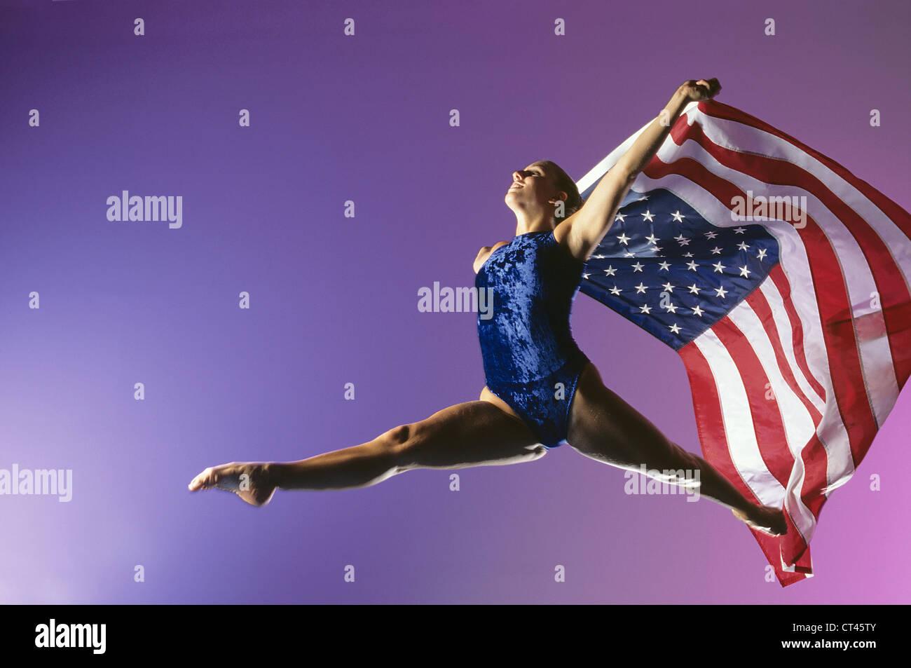 Olympiasieger springt, während er eine amerikanische Flagge hält Stockfoto