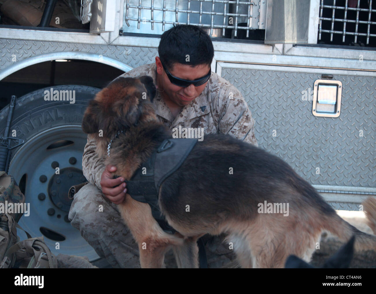 Cpl. Fidel Rodriguez, ein militärischer Arbeitshundeführer mit 1. Strafverfolgungsbataillon, I Marine Expeditionary Force, erhält einige Zuneigung von seinem Hund, Aron, während einer Trainingsübung in großem Maßstab Übung-1, Javelin Thrust 2012, 7. Juli. Javelin Thrust ist eine jährliche groß angelegte Übung mit 1. Marine Expeditionary Brigade am Marine Corps Air Ground Combat Centre Twentynine Palms, Kalifornien, die aktiven und Reserve Marines und Matrosen aus 38 verschiedenen Staaten ermöglicht, zusammen als nahtlose Marine Air Ground Task Force zu trainieren. Stockfoto