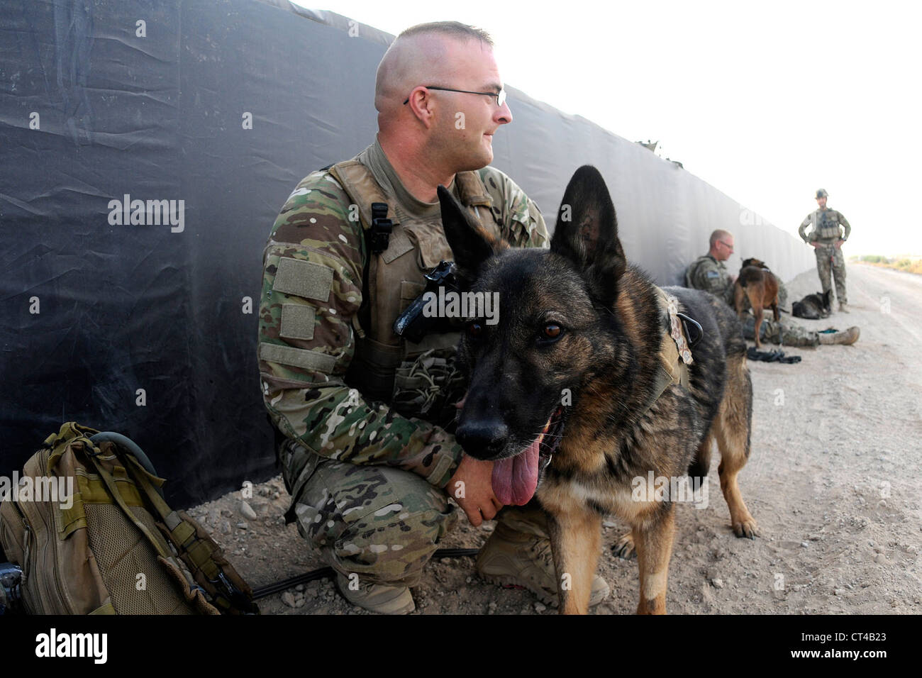 US Air Force Tech Sergeant Matthew Mosher, eine militärische arbeiten Hund, Hundeführer und seinen Hund Zix, eine Patrouille Explosive Erkennung Hund, vor dem Training am frühen Morgen am 9. Juli 2012 am Kandahar Flugplatz, Afghanistan. Handler und ihre Hunde drehen durch Kandahar Flugplatz für die Validierung vor dem Umzug nach vorwärts operative Grundlagen rund um das Land, wo sie führen Kampf Fuß Patrouillen und IEDs und andere Explosivstoffe erschnüffeln. Stockfoto