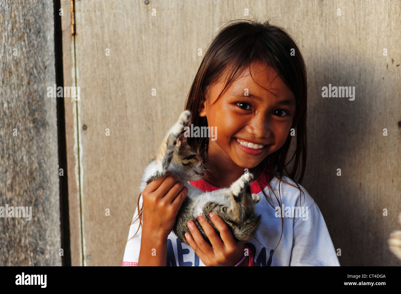 Malaysia, Borneo, Semporna, Mabul, lächelnde junge Mädchen mit Katze Stockfoto