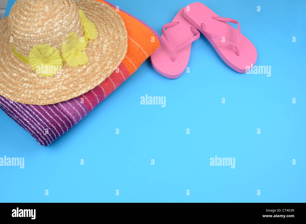 Sommer-Konzept, Bild von einem weichen bunten Strandtuch mit rosa Flip flops und einem Strohhalm Sonnenhut Stockfoto