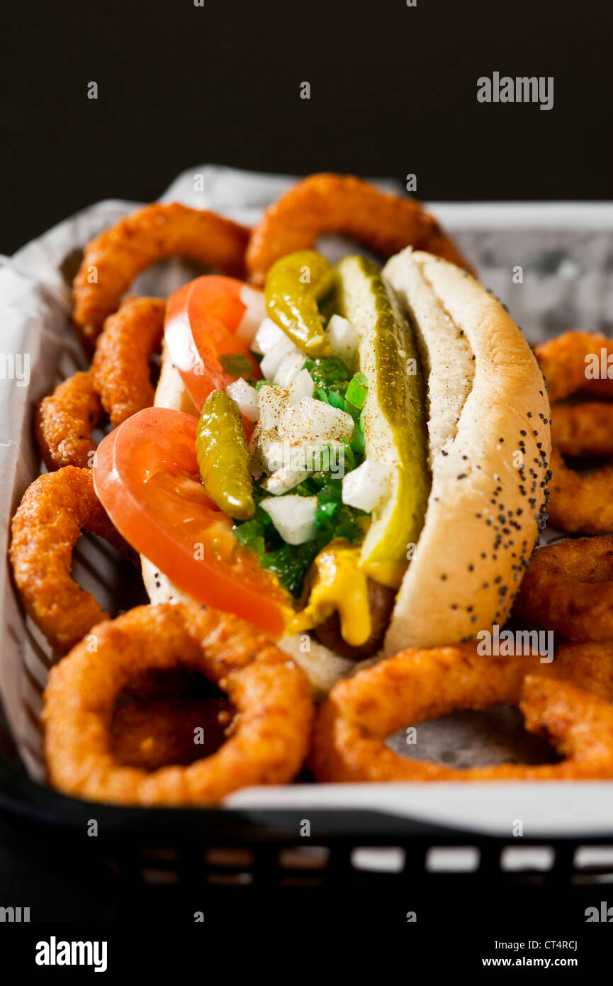Ein Chicago Hot Dog und Zwiebel Ringe in einem Korb. Stockfoto