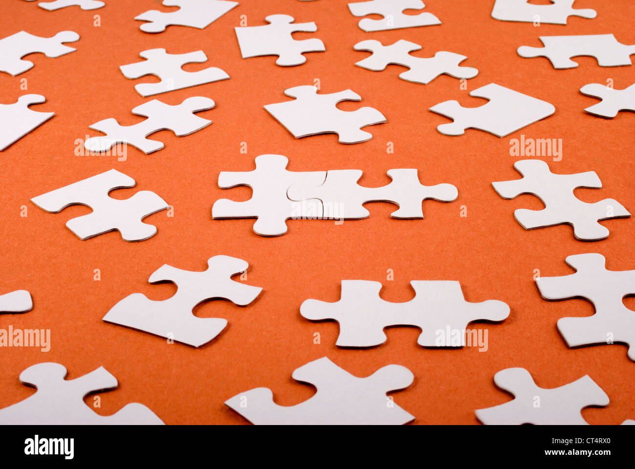 Viele Puzzleteile ausgebreitet, mit zwei miteinander verbunden Stockfoto