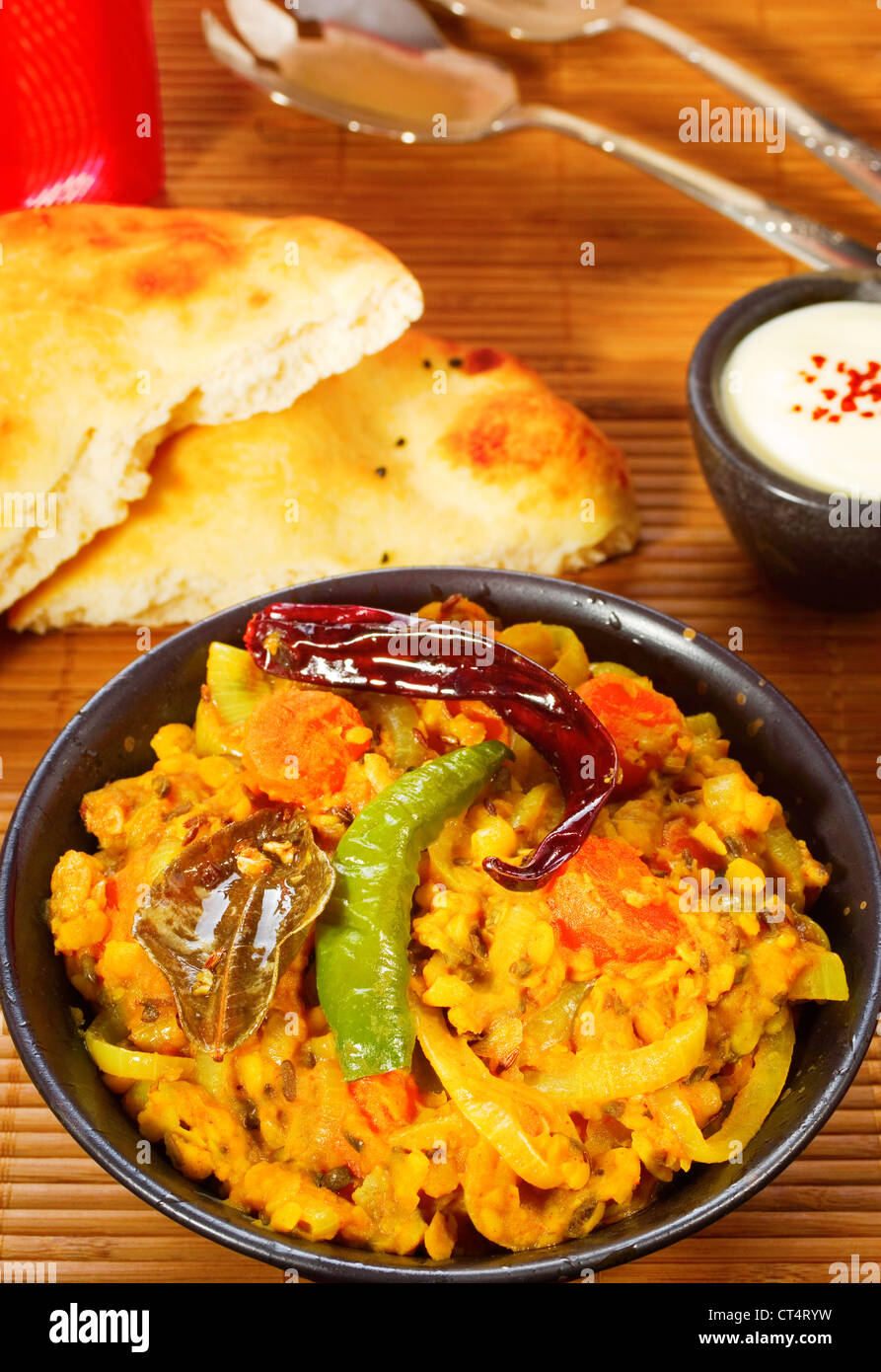 Indische vegetarische Mahlzeit würzige Linsensuppe Dal, mit Chili, Naan-Brot und Joghurt. Stockfoto