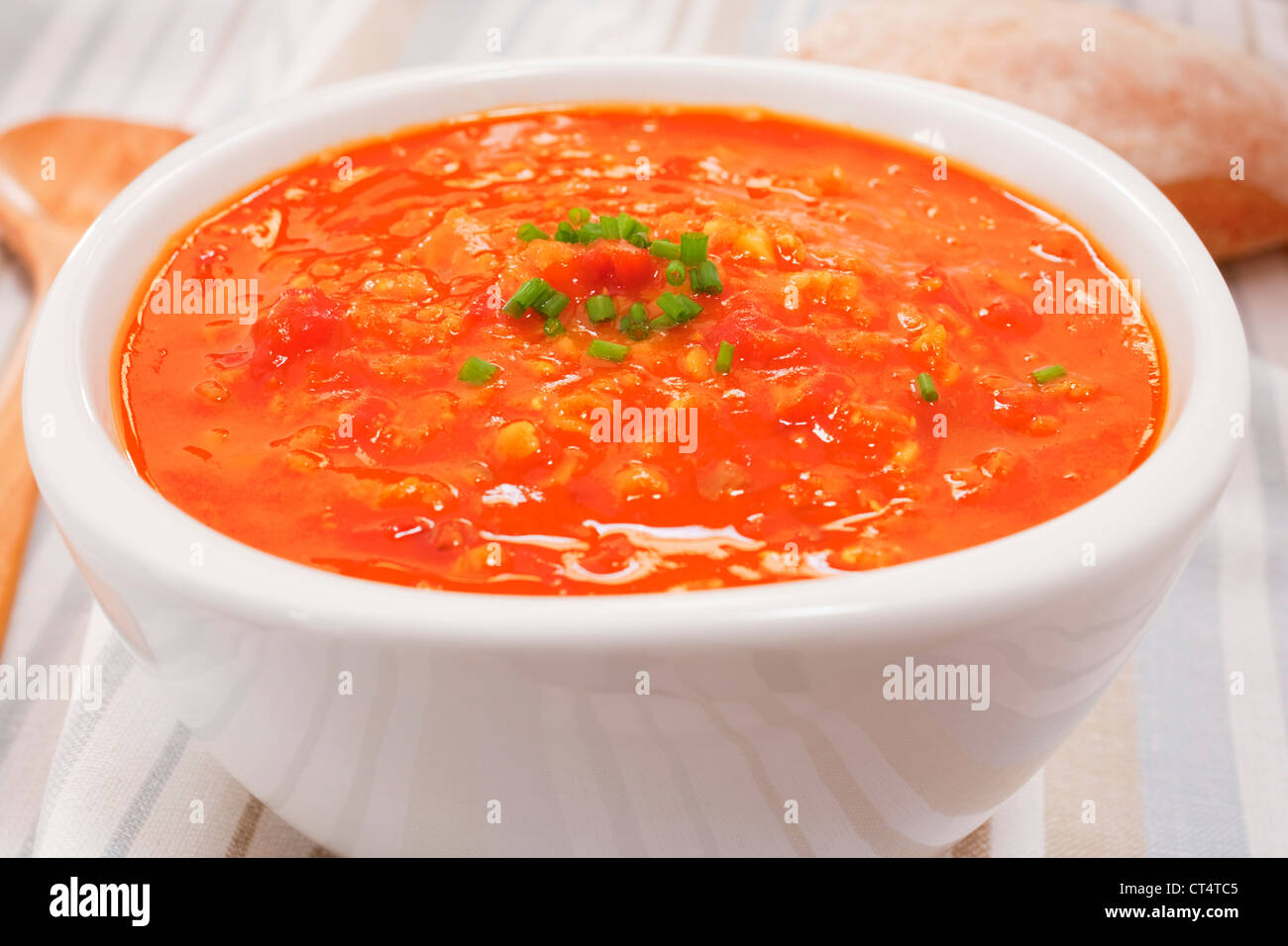 Eine Schüssel mit Linsen und Tomaten Suppe Garmished mit Schnittlauch. Stockfoto