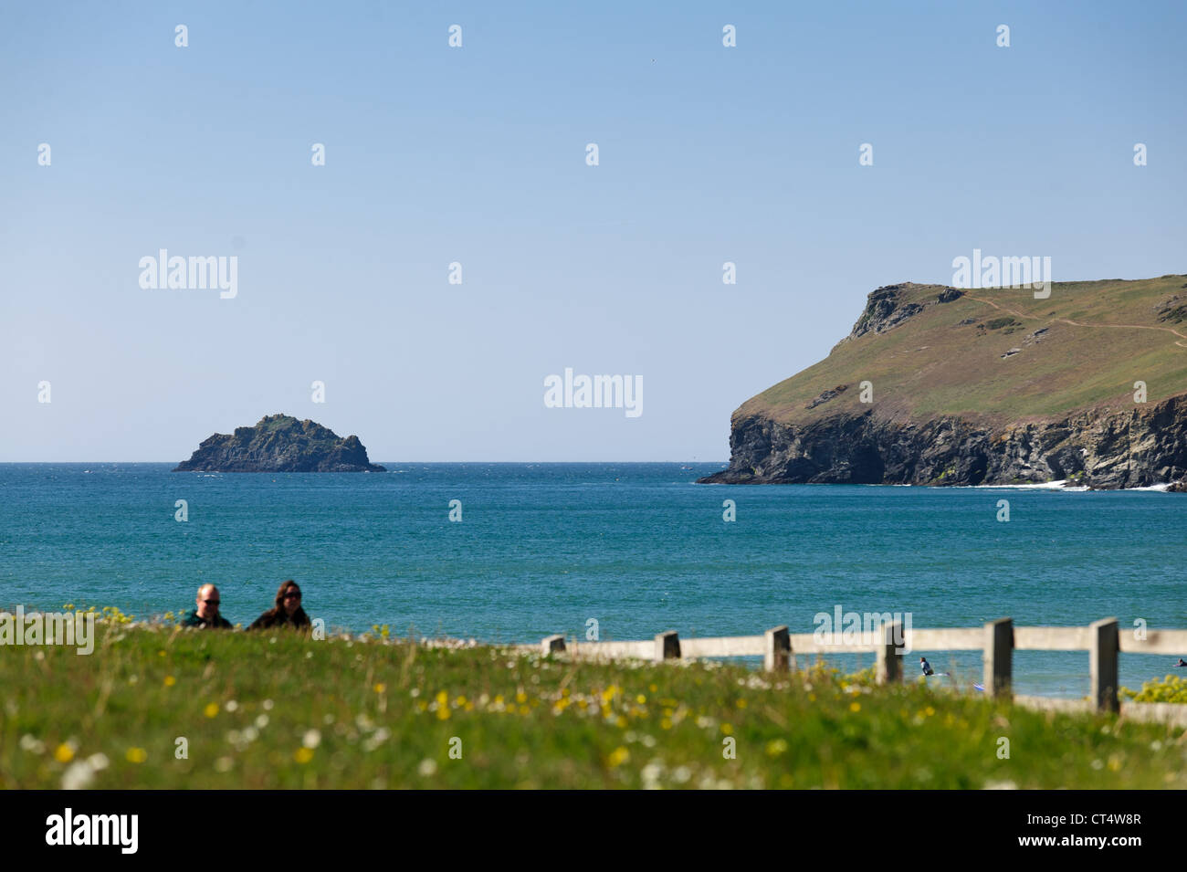 Zwei Wanderer auf dem Küstenweg Polzeath Bay an einem sonnigen Sommertag in Cornwall Stockfoto