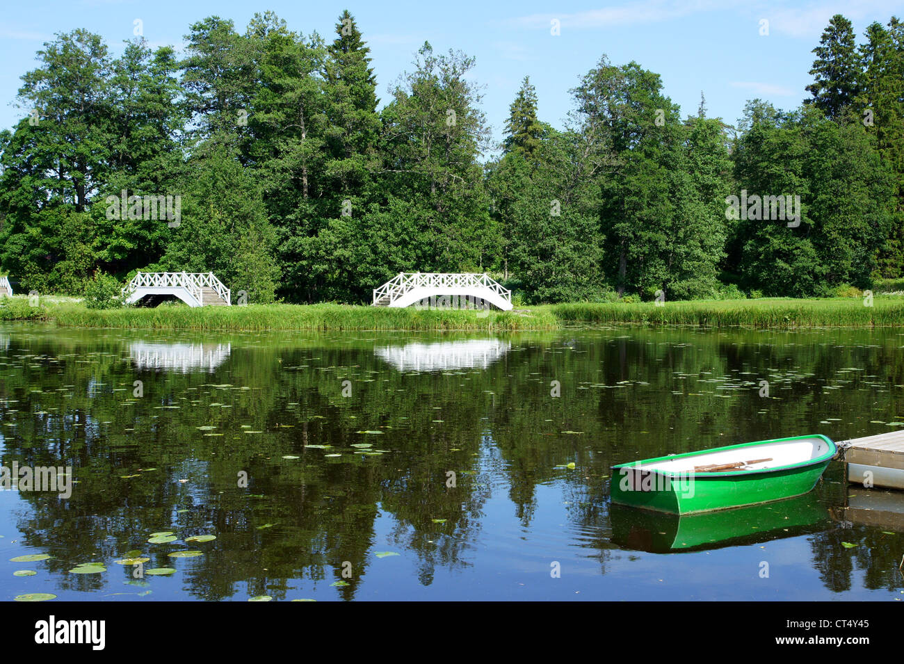 Die weiße Brücke auf einem Hintergrund von einem Teich und Bäumen Stockfoto