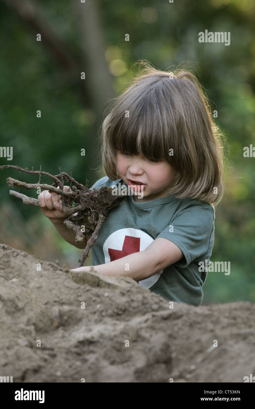 Ein Junge spielt in den Sand mit einem Stamm Stockfoto