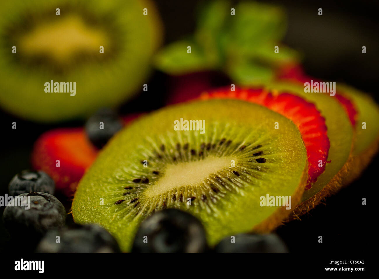 Frisch geschnittene Kiwi und Erdbeeren mit Heidelbeeren Stockfoto